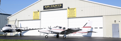 Airplanes parked in front of a hangar